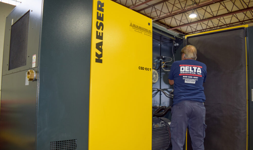 Delta Industries technician working on air compressor.